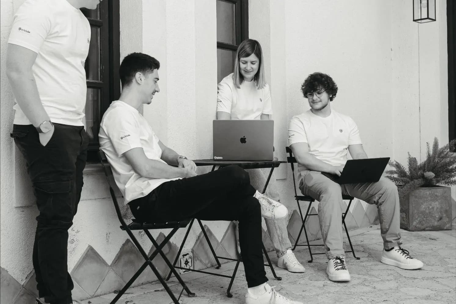 The team gathers around a MacBook, hard at work